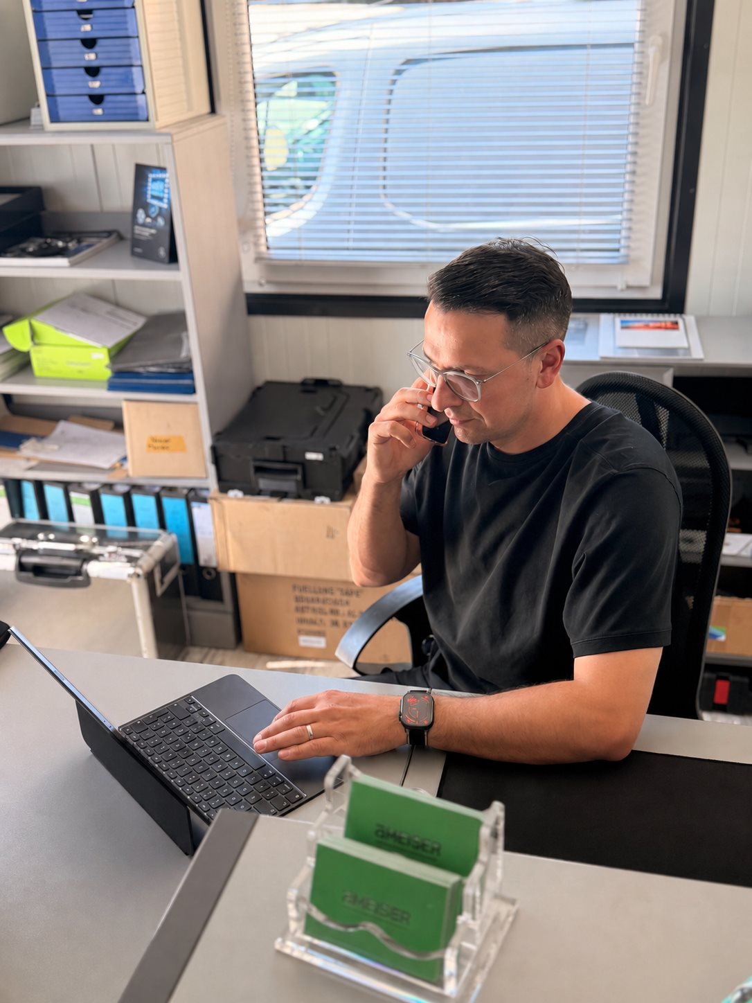 Kfz-Sachverständiger Vadim Ameiser im Sachverständigenbüro am Telefon